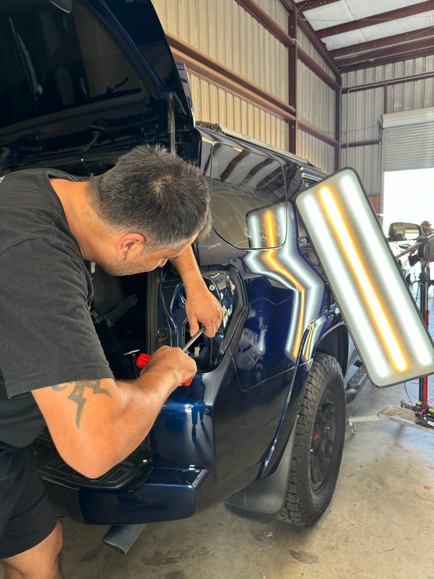 Technician repairing a rear quarter panel